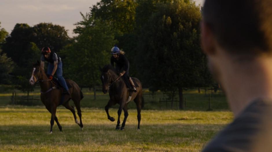 Will watches two people ride past on horseback.