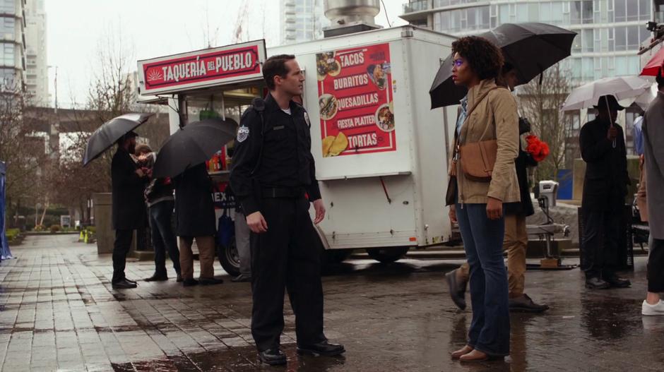 A police officer approaches Erika after her eyes started to glow purple.