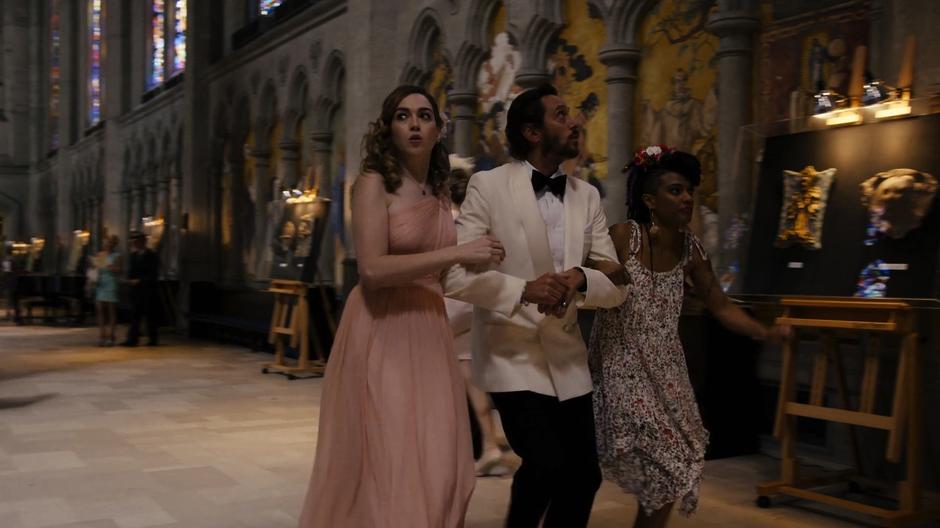 Nomi, Bug, and Amanita rush through the lobby of the cathedral.