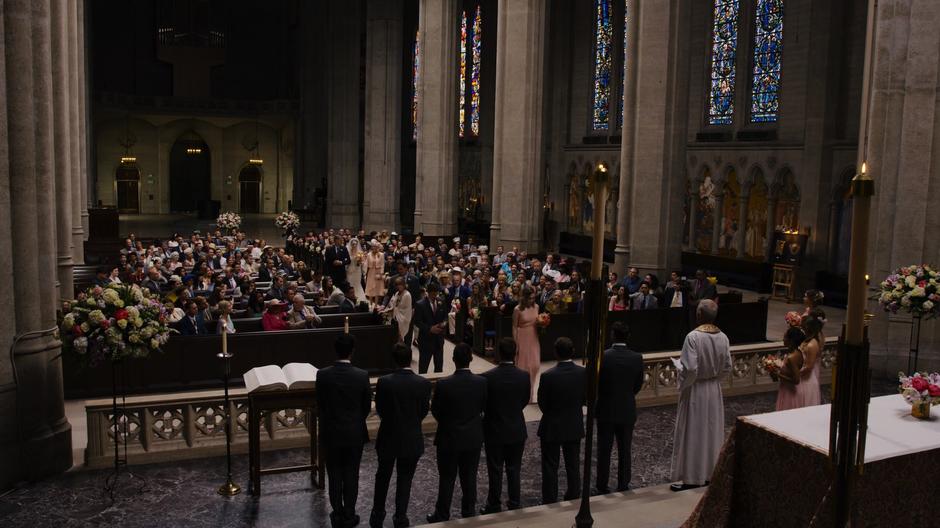 Nomi approaches her place up front while Teagan walks down the aisle with her mother and father.