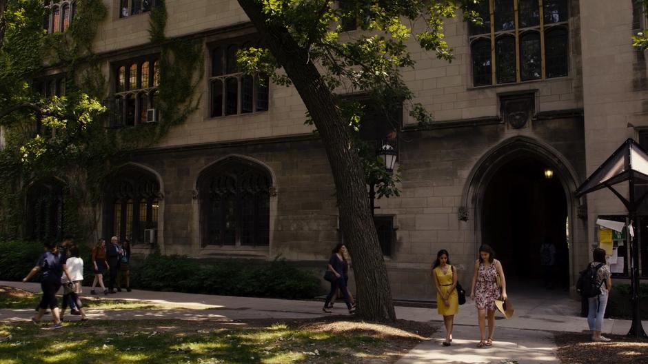 Nomi and Amanita walk with Professor Kolovi towards his office.