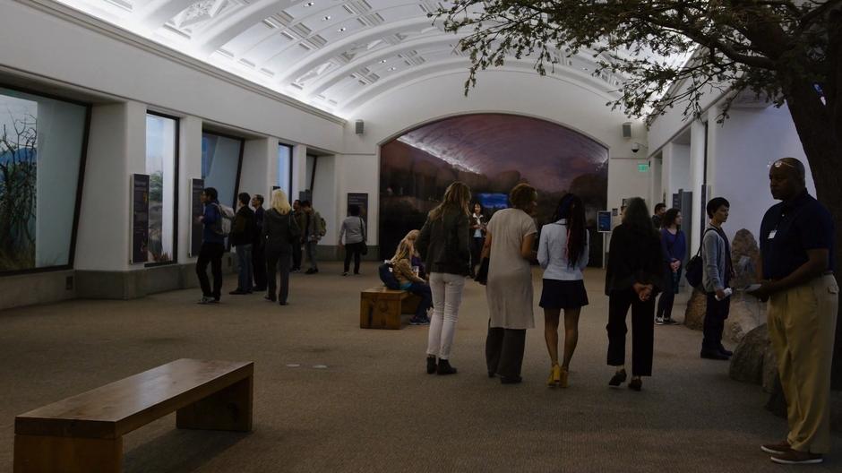 Nomi, Dr. Bradley, Amanita, and Grace walk through the museum while Dr. Braley talks about Professor Kolovi.