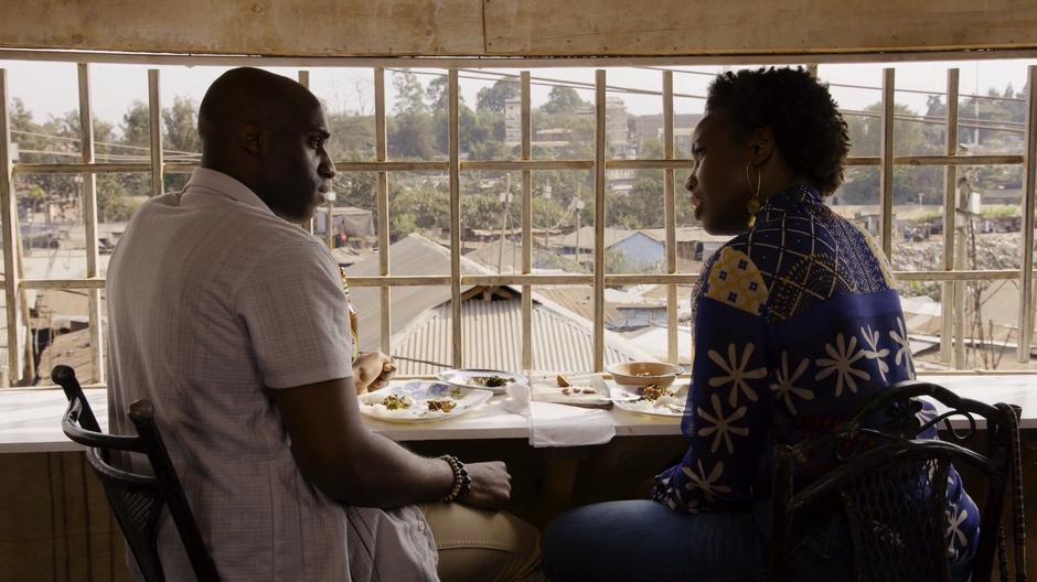 Capheus and Zakia talk over their finished meal at the window.