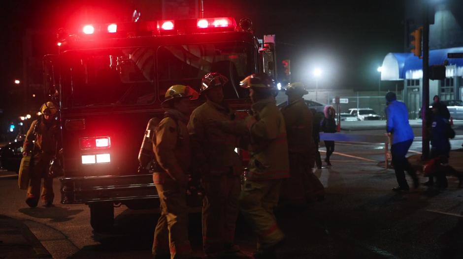 Several firefighters exit the truck and prepare to stop the fire.