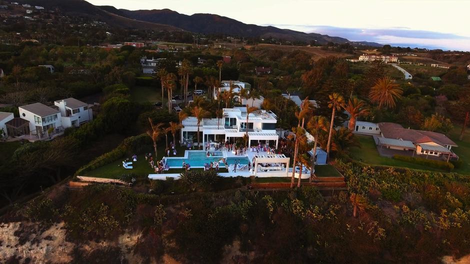 View from above the clifftop mansion where a raucous party is being held.