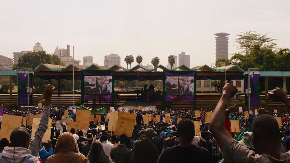 Jala points up to the big screen that he appears on with Capheus while the crowd cheers for their arrival.