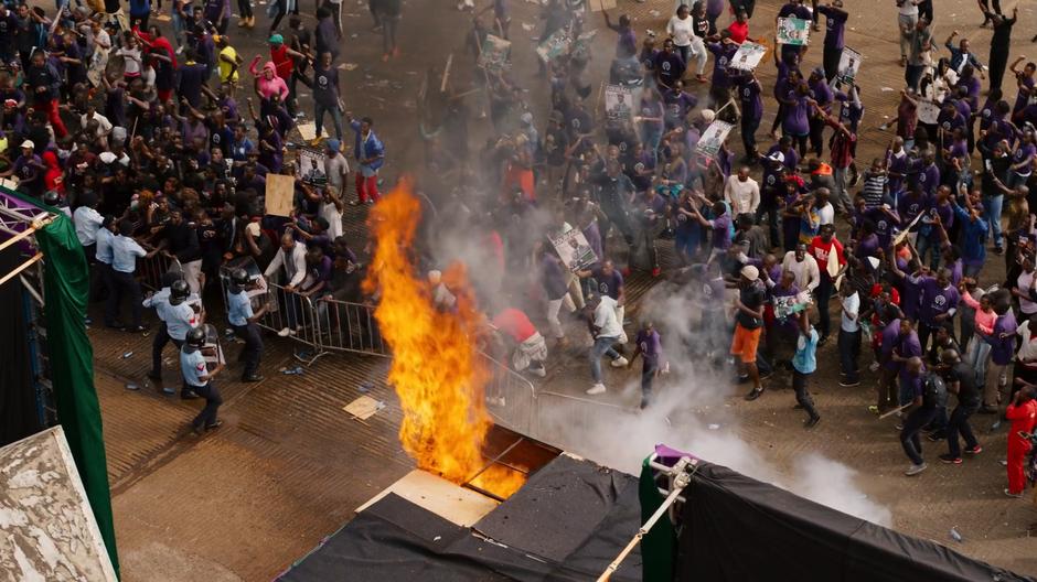 The police try to hold back the panicking crowd as a corner of the stage burns.