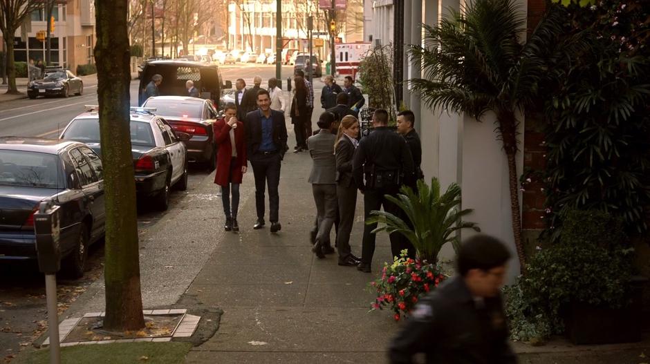 Chloe drinks the coffee Lucifer gave her while walking with him towards the crime scene.