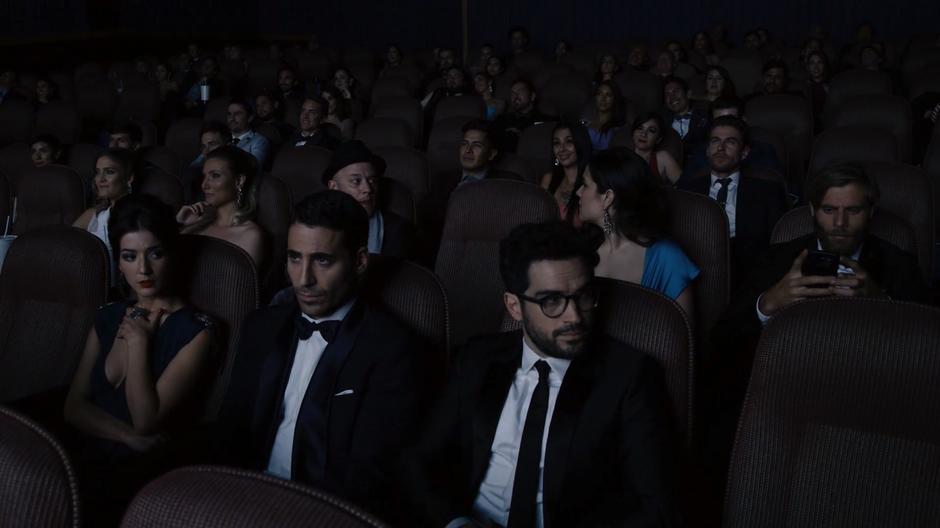 Dani and Hernando look around at the crowd during the kissing while Lito stares at the screen.