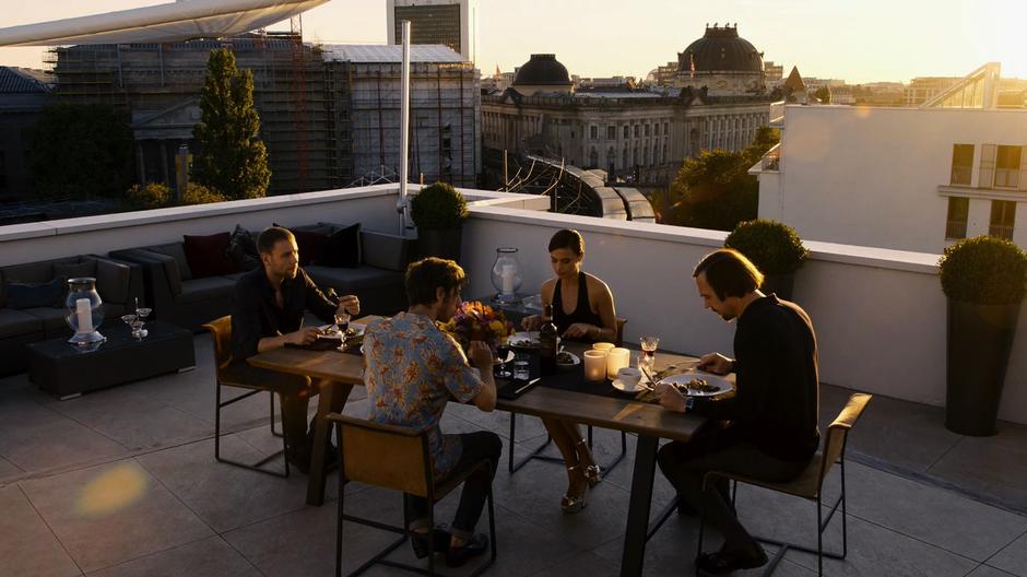 Wolfgang, Felix, Lila, and Sebastian share a meal out on the balcony.