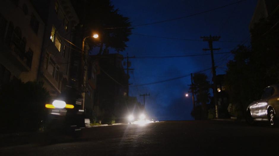 Bendix's car sparks after he jumped the hill and Amanita drives her motorcycle away in front of him.