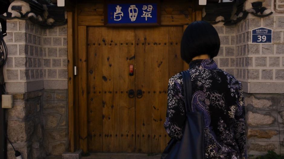 Sun approaches the front door of her teacher's home.