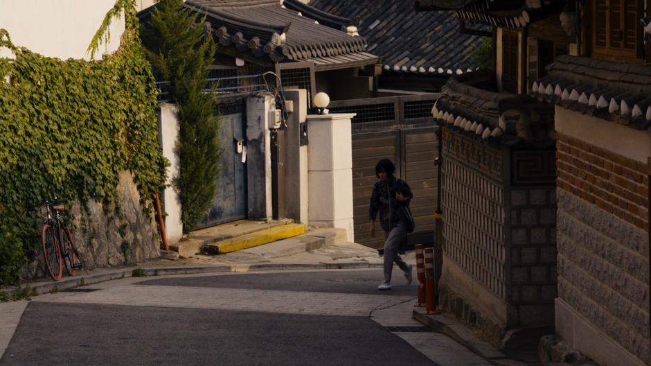 Sun walks up the street towards the house.