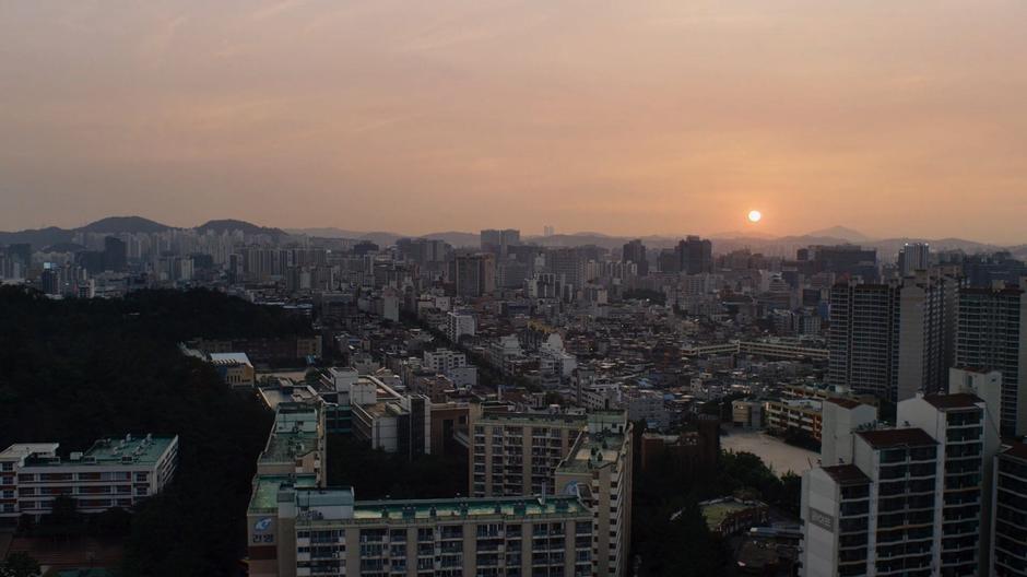 The apartment building sits in front of the sunrise.