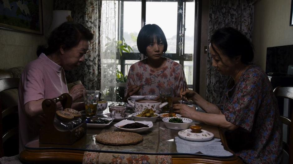 Min-Jung and Sun listen to Mrs. Cho tell about why she ended up in jail while they eat their breakfast.