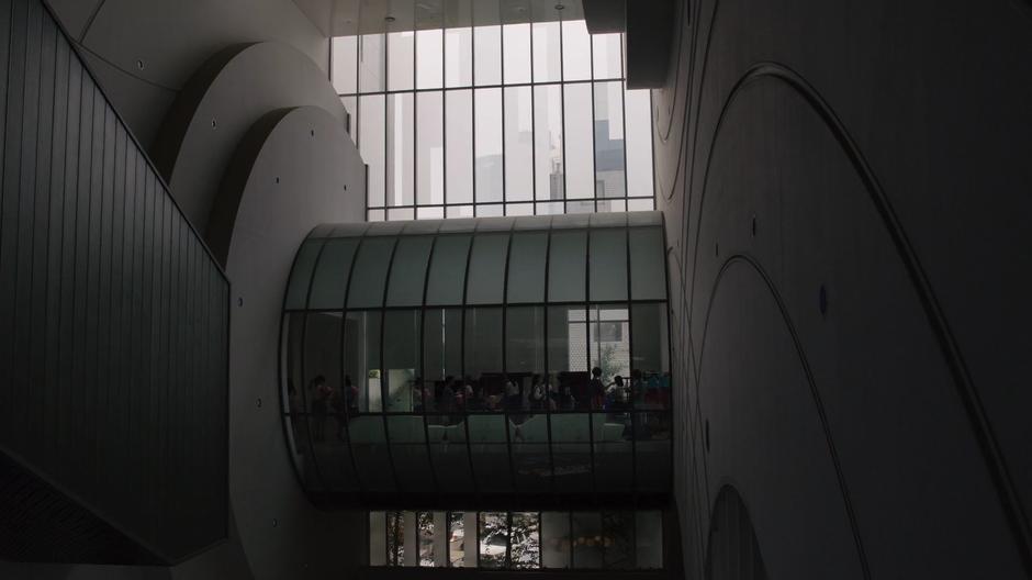 The workers mill around inside a glass cylinder while picking up their outfits.