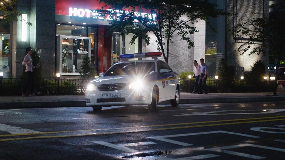 A police car turns to block the road in front of Joong-Ki.