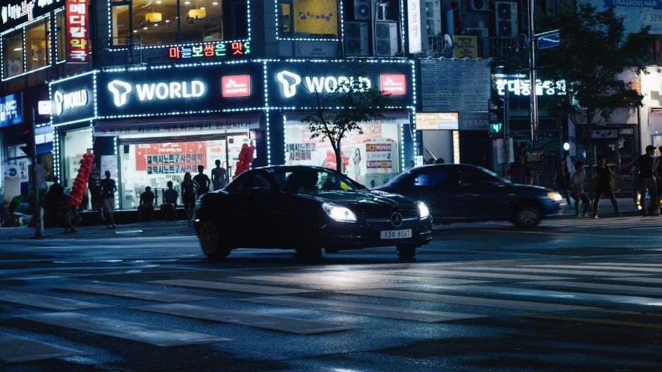 Joong-Ki drives away through the intersection.