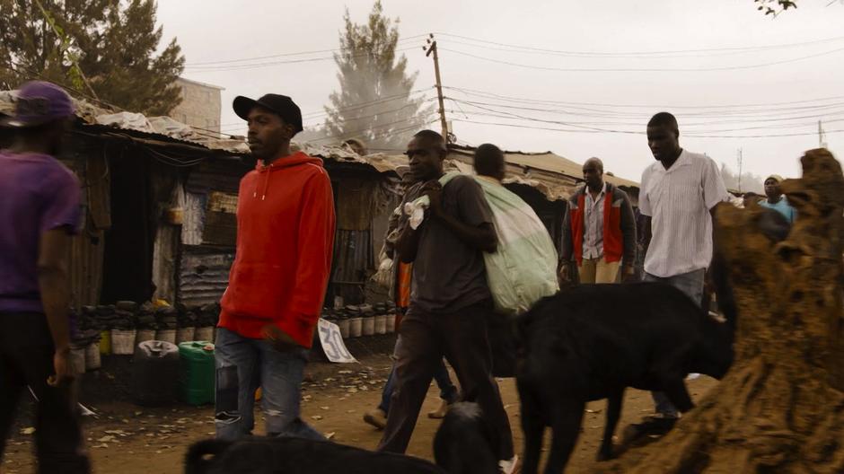 Capheus walks down the busy street towards his home.