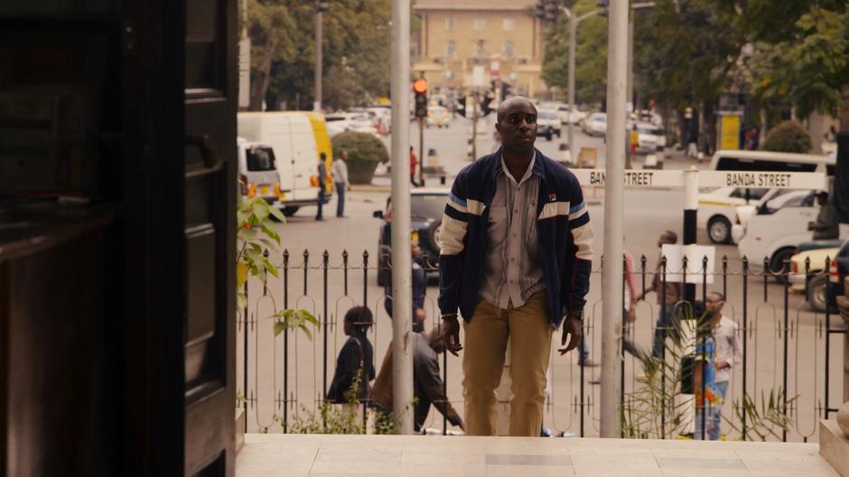 Capheus walks up the steps to the offices.