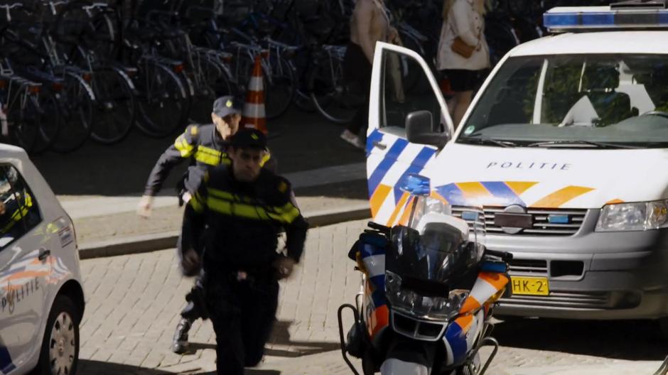 Two police offices exit their car and run to the museum.