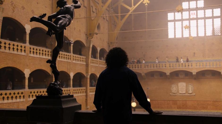 Jonas looks out from the balcony towards the bright windows.