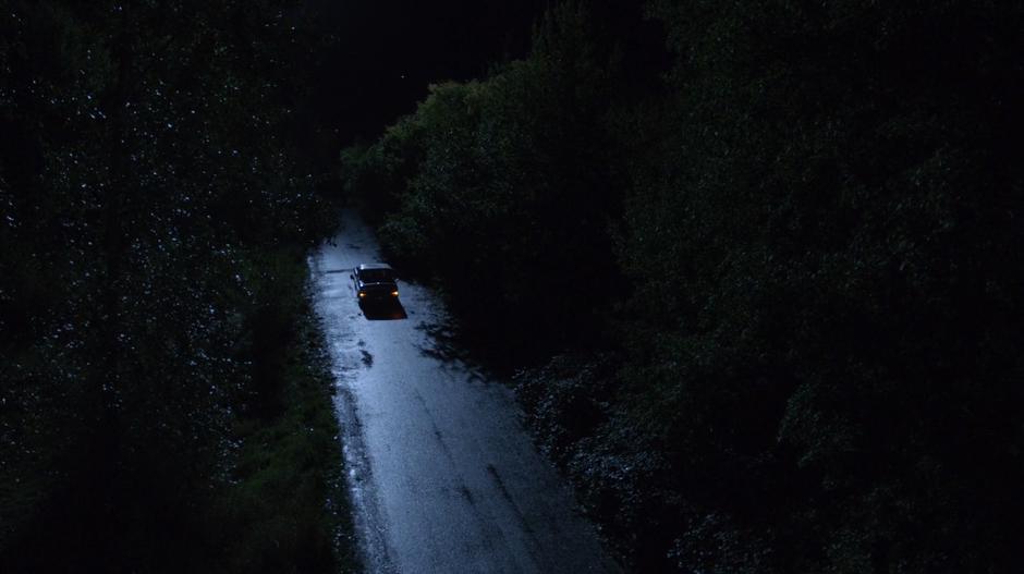 The pickup truck drives down a darkened street.