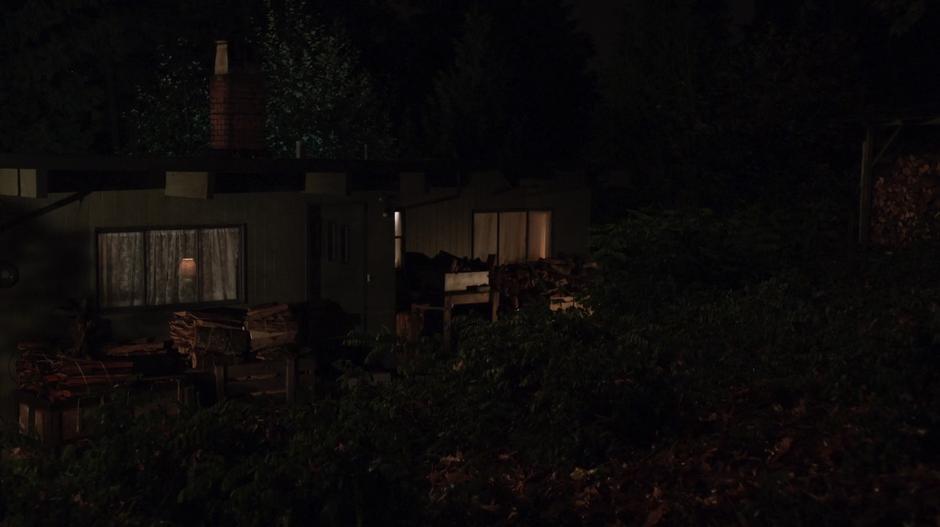 Establishing shot of the front of the cabin at night.
