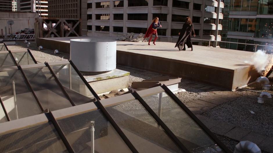 Kara runs along the rooftop at Rhea.