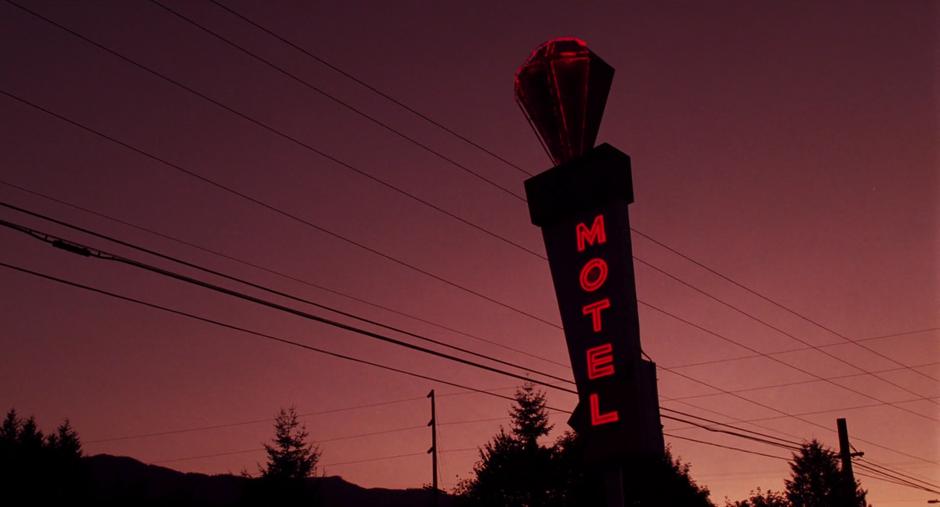 Establishing shot of the motel sign at dusk.