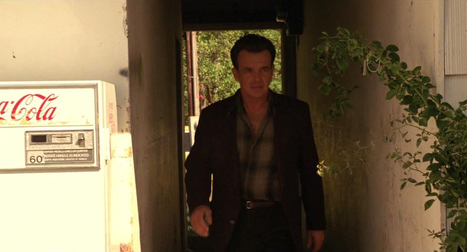 Leland Palmer walks into the model through an outdoor hallway.