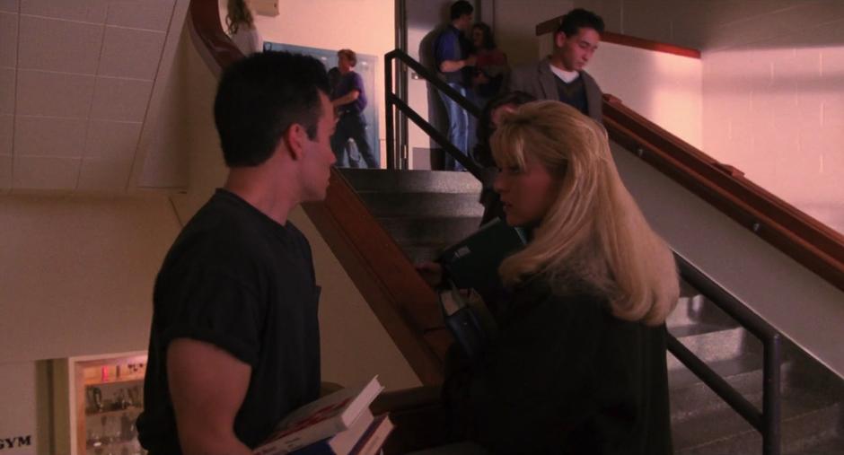 James talks to Laura on the stairs of the school.