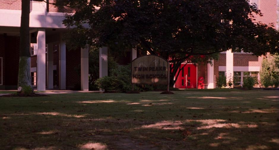 Establishing shot of the front of the school with the *Twin Peaks High School* sign.