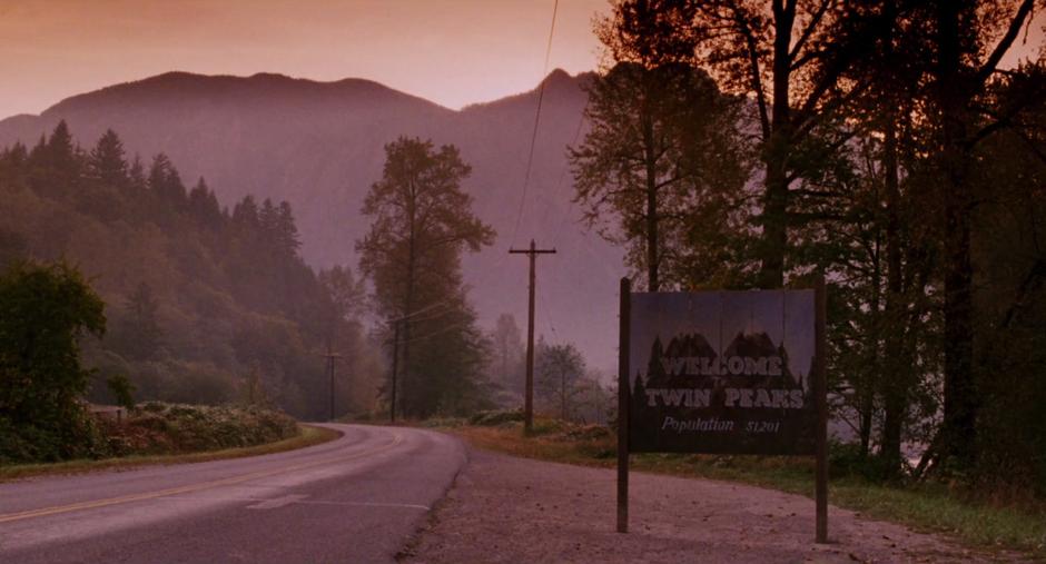 Establishing shot of the sign beside the road.