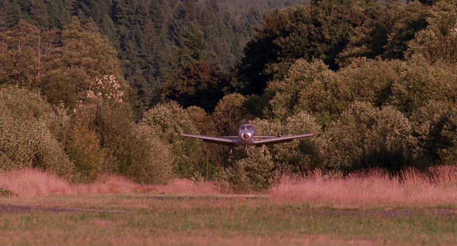 Chet's plane lands on the grass airstrip.