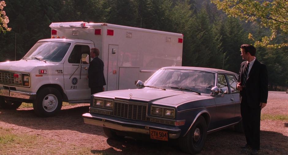 Sam and Chet check out the FBI van that recently arrived to pick up the body looking for the other agents.