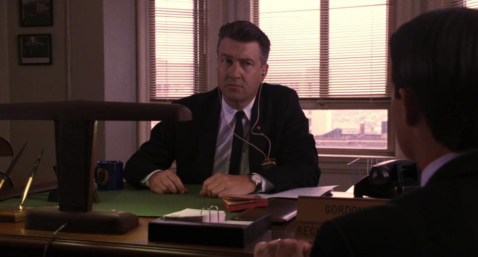 Gordon Cole sits at his desk talking with Special Agent Dale Cooper.