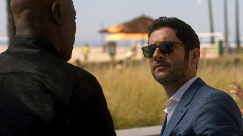 Lucifer looks up at Amenadiel while they chat.