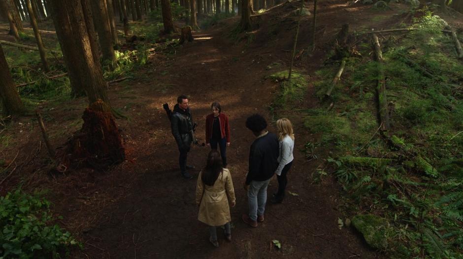 Samantha, Curtis, and Felicity stand around Thea while Merlyn talks about how to get her off the land mine.