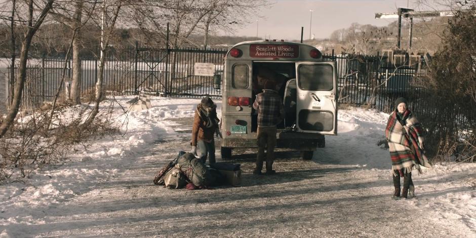 The other survivors unload their gear from the truck they've been traveling in.