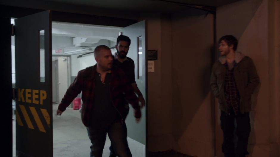 Harley Johns leads Ravi out of the morgue's loading door into the alley where one of his compatriots is waiting.
