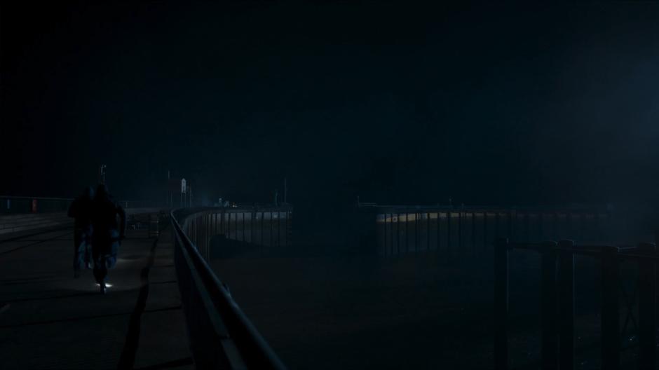 Two guards run down the pier to where the ship if approaching.