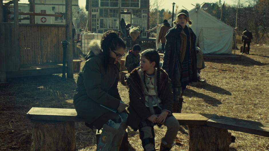 Cosima talks to Charlotte out front of the school while Mud looks on.