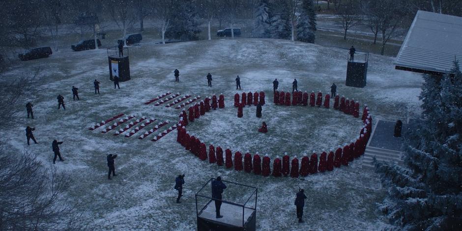 Offred talks to Aunt Lydia in the middle of the circle after dropping her stone.