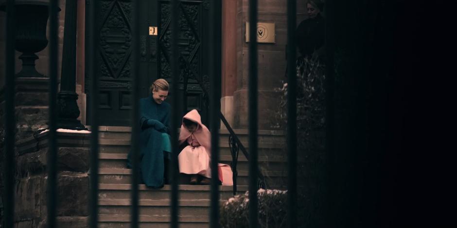 Serena sits on the steps of the building talking to Hannah.