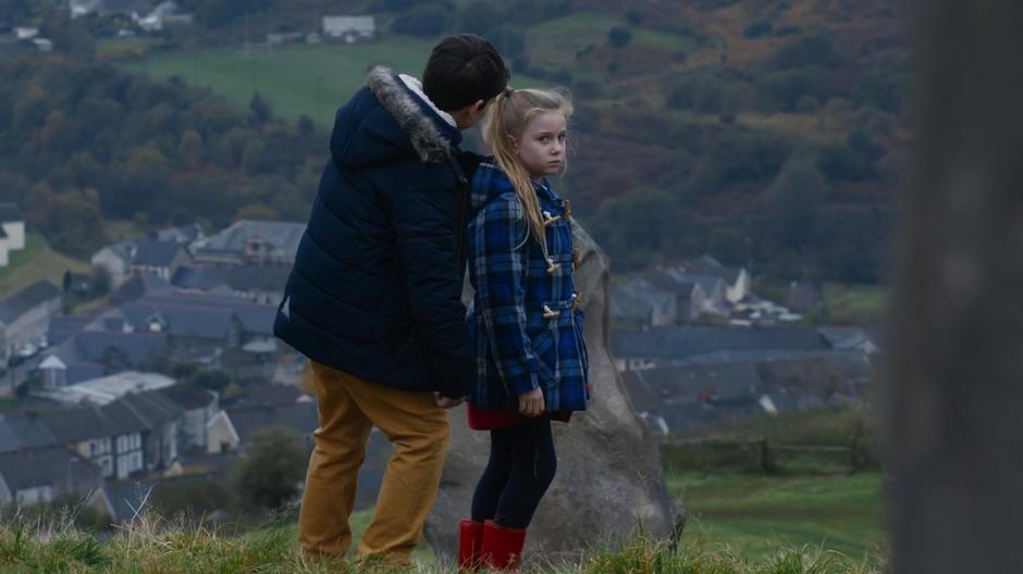 The girl's brother tries to get her to head down the hill back to town.