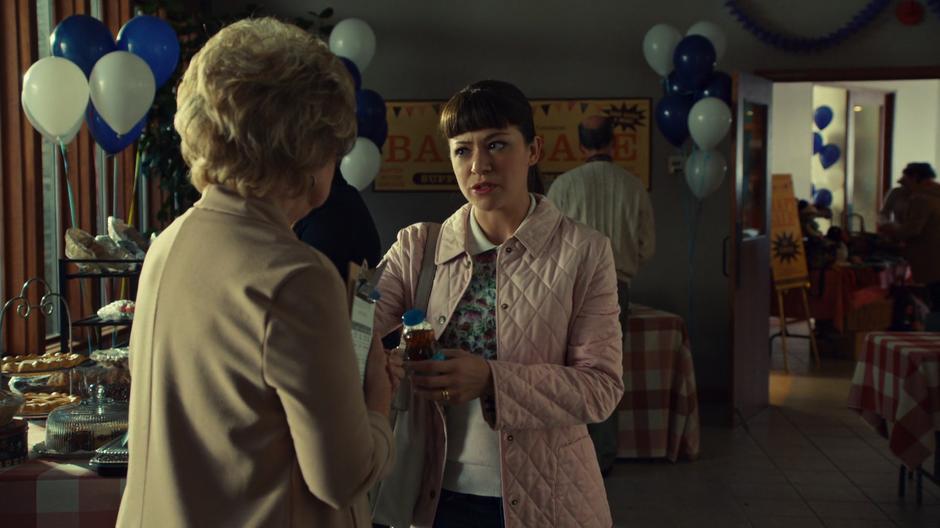 Alison offers the drugged bottle of iced tea to Nona Walker.