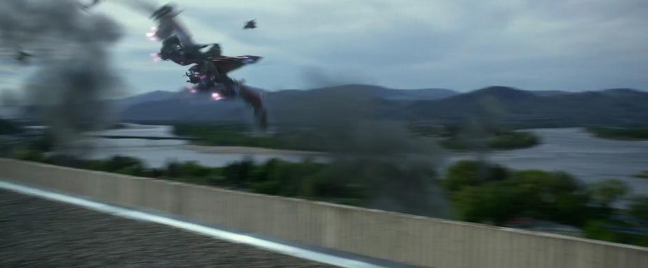 The pink Zord flies past the rooftop with the river in the background.