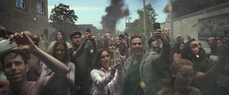 A crowd of people snaps photos of the Megazord with their phones.