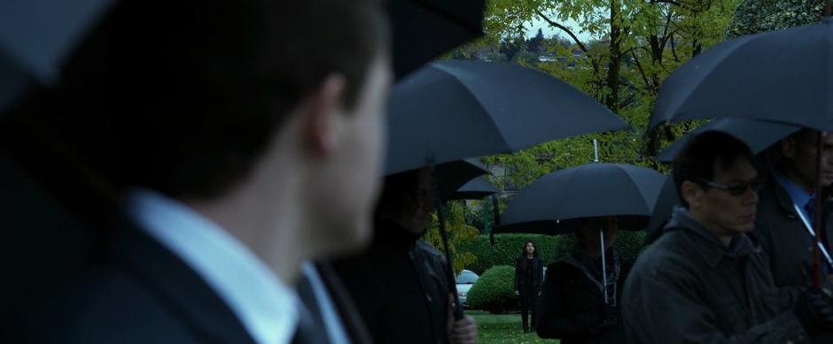 Jason looks through the crowd of mourners and sees Kimberly standing at the edge of the cemetery.